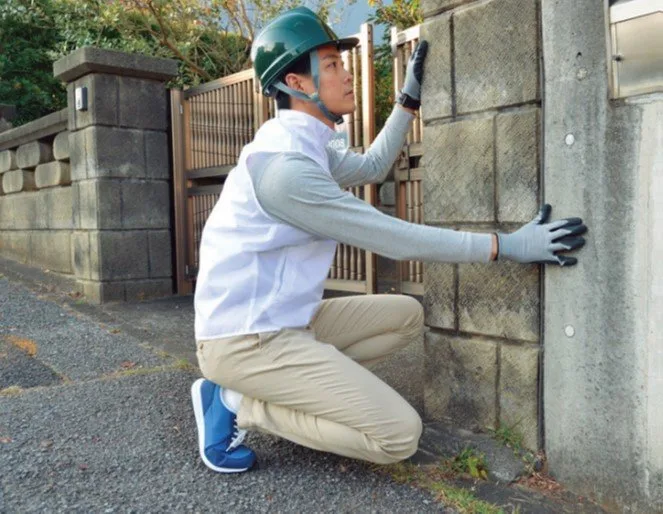 外壁の点検を行うスタッフ